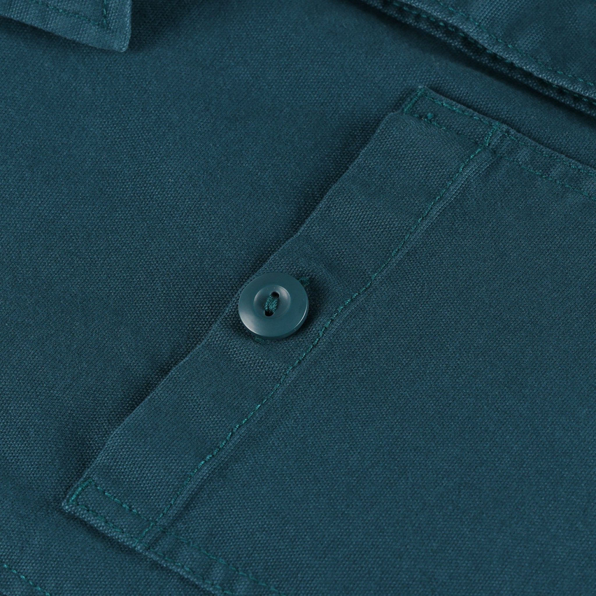 General shot of Topo Designs Men's Dirt shirt Jacket in Pond Blue showing BDU button on chest pocket.