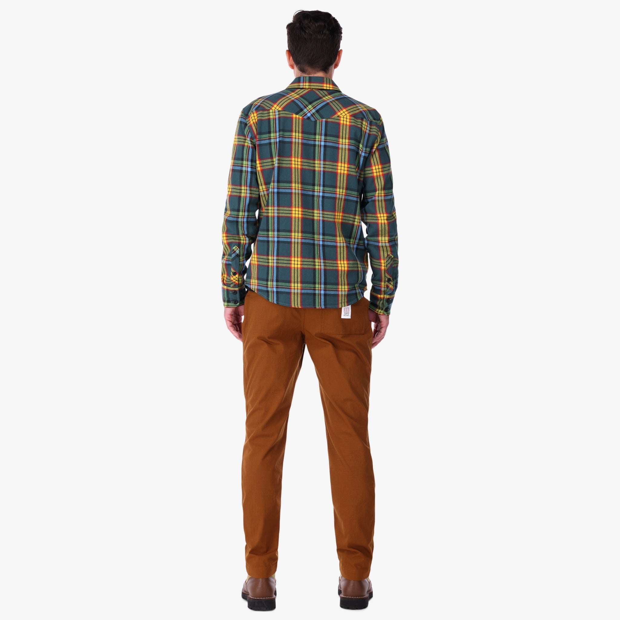 Back of Topo Designs men's mountain organic cotton flannel shirt in "green multi" plaid on model.