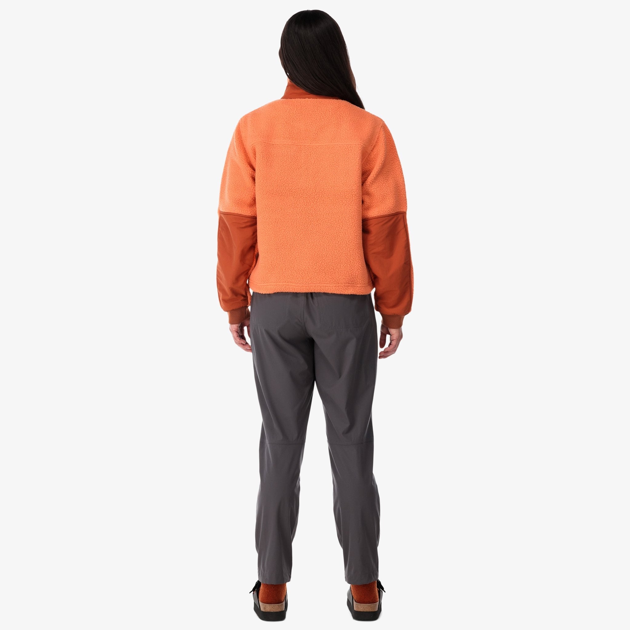 Back shot of Topo Designs Women's Mountain Fleece Pullover in "Rust / brick" pink orange on model.