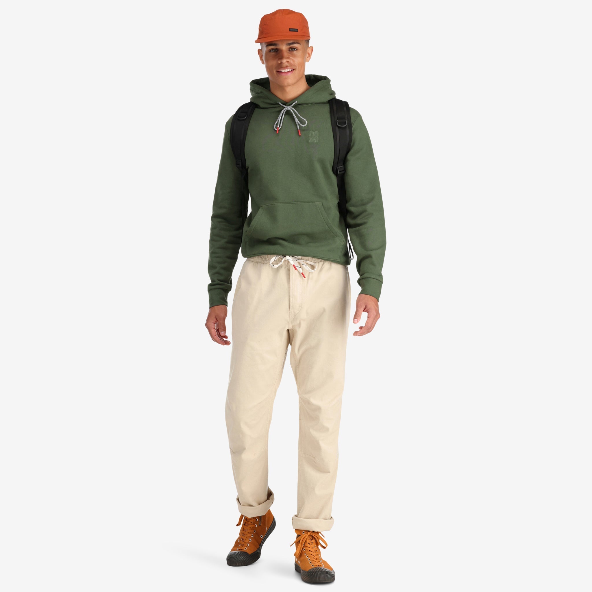 Front model shot of Topo Designs Men's Dirt Pants 100% organic cotton drawstring waist in "Sand" white show on "charcoal" & "brick"