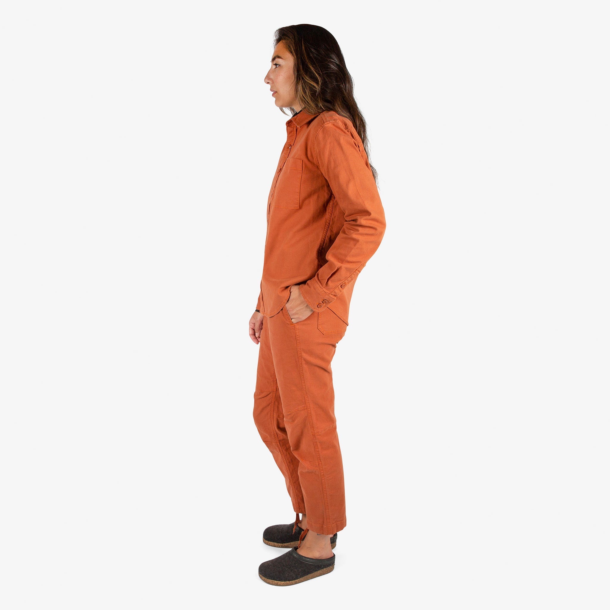 Side model shot of Topo Designs Women's Dirt Shirt & Pants in "Brick" orange. Show on "Peppercorn" & "Black"