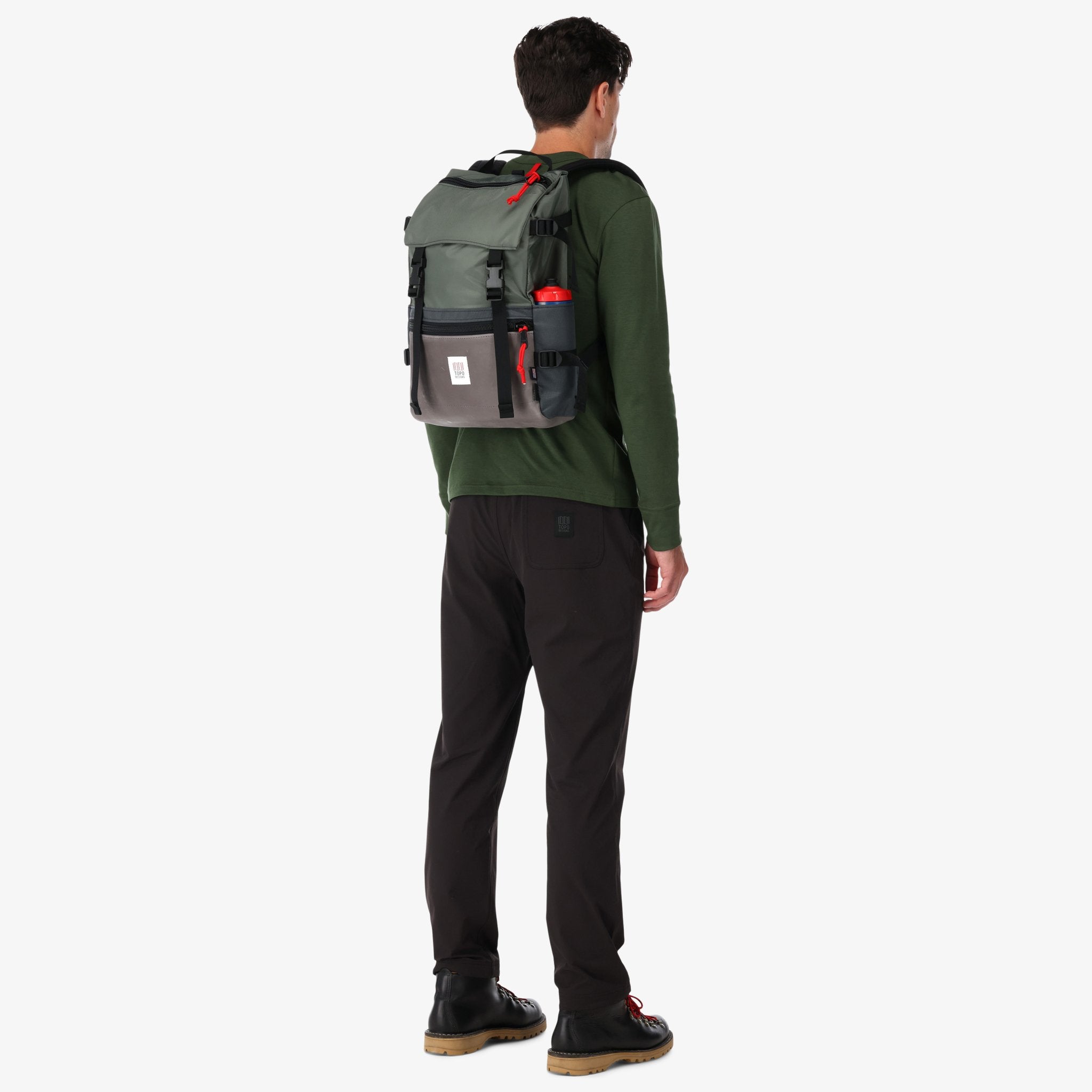 Topo Designs Rover Pack Heritage Made in the USA Backpack in Charcoal gray Leather on model's back with water bottle in sleeve.