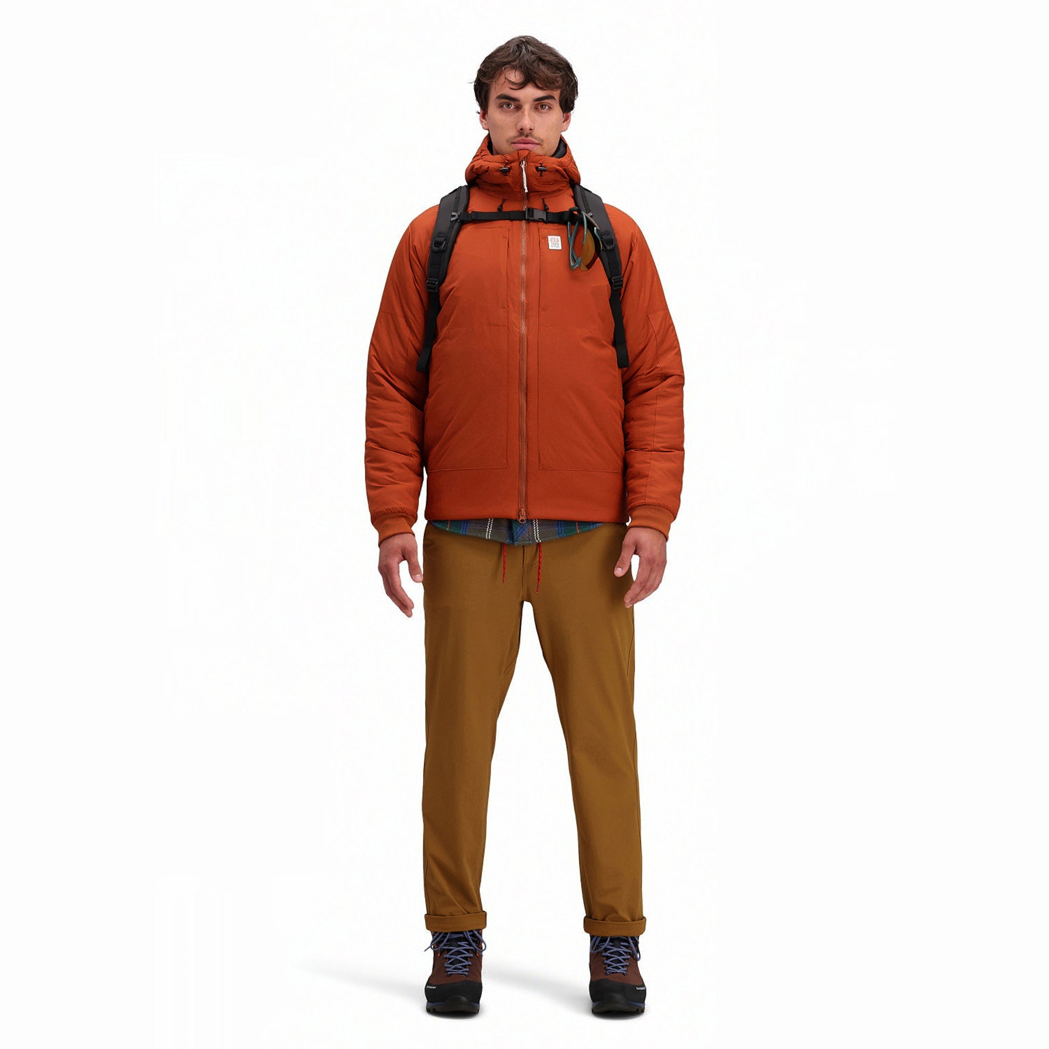 Front model shot of Topo Designs Mountain Puffer Primaloft insulated Hoodie jacket in "Brick" orange